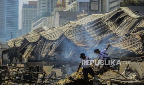 Petugas melintas di lokasi pasca kebakaran di Pasar Kambing, Tanah Abang, Jakarta, Jumat (9/4). Sebanyak 136 lapak dan 40 kios pedagang terbakar yang diduga akibat korsleting listrik dan tidak ada korban jiwa dalam peristiwa tersebut. Selanjutnya, Pemerintah Provinsi DKI Jakarta akan menata ulang pasar tersebut. Republika/Putra M. Akbar