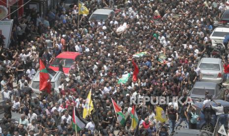 Ratusan pelayat Palestina bergabung dalam prosesi pemakaman 13 warga Palestina yang tewas dalam serangan tentara Israel di kota Jenin, Tepi Barat, 05 Juli 2023.