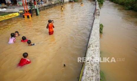 Sejumlah bocah bermain di Perumahan Mustika yang terendam banjir di Tigaraksa, Kabupaten Tangerang, Banten, Rabu (20/5/2020). Banjir akibat luapan sungai Cimanceuri yang terjadi sejak Selasa (19/5) siang tersebut mulai berangsur surut