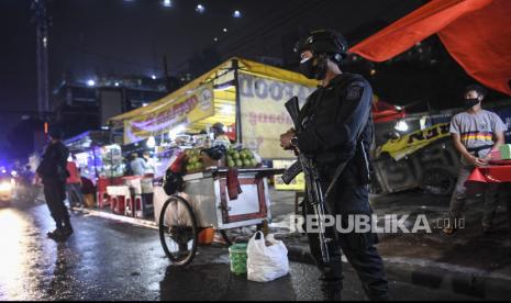 Personel kepolisian melakukan patroli pengawasan protokol kesehatan di kawasan kuliner Jalan Sabang, Jakarta, Jumat (18/6/2021). Gubenur DKI Jakarta Anies Baswedan menyatakan bahwa seluruh kegiatan di Jakarta dibatasi hingga 21.00 WIB sesuai dengan Pemberlakuan Pembatasan Kegiatan Masyarakat (PPKM) menyusul meningkatnya kasus COVID-19 di Jakarta.  