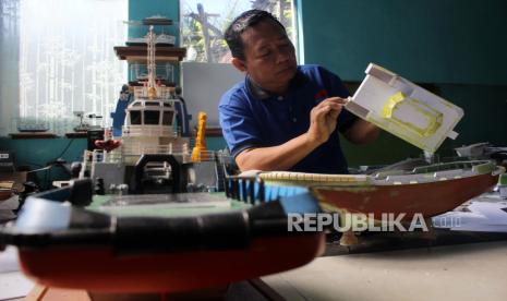 Perajin miniatur kapal Cakraningrat Ship Model Abdul Halim menyelesaikan pembuatan miniatur kapal di Dusun Dumarah, Kecamatan Kamal, Bangkalan, Jawa Timur, Jumat (3/6/2022). Kerajinan miniatur kapal berbahan triplek tersebut dijual melalui pasar digital dan melayani permintaan dari luar kota hingga luar pulau seperti Balikpapan, Papua, dan Sumatera dengan harga berkisar Rp750 ribu hingga Rp15 juta tergantung ukuran dan kesulitannya. 