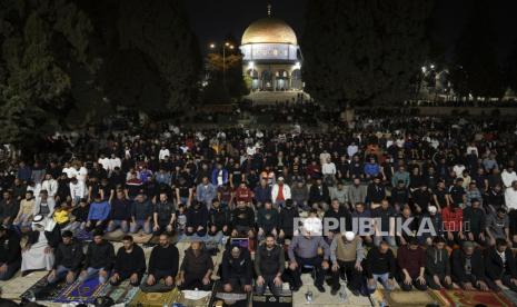 Jamaah Palestina melakukan shalat tarawih,pada bulan suci Ramadhan, di sebelah Dome of Rock di kompleks Masjid Al-Aqsa di Kota Tua Yerusalem, Sabtu (8/4/2023). Menteri Pertahanan Israel pada hari Sabtu memperpanjang penutupan larangan masuk ke Israel bagi warga Palestina dari Tepi Barat dan Jalur Gaza yang diduduki selama liburan Paskah Yahudi, sementara polisi meningkatkan pasukan di Yerusalem pada malam perayaan keagamaan yang sensitif. Netanyahu Larang Pemukim Kunjungi Masjid Al Aqsa Hingga Akhir Ramadhan