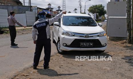 Ratusan Kendaraan Dihalau Masuk Wonosobo , Petugas mengarahkan kendaraan untuk diperiksa saat uji coba pengendalian moda transportasi (Daltrans), di Posko Kertek, Wonosobo, Jawa Tengah. Kegiatan terpadu Gugus Tugas Percepatan Penanganan COVID-19 kabupaten Wonosobo untuk memutus mata rantai penyebaran penyebaran virus corona atau COVID-19 tersebut akan diterapkan penuh pada 8-31 Mei 2020