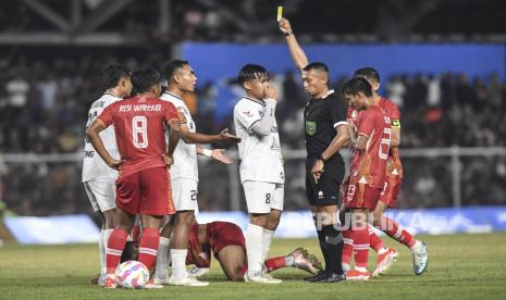 Wasit Eko Agus Sugiharto (kedua kanan) memberikan kartu kuning kepada pesepak bola Sulawesi Tengah Ichansyah (ketiga kiri) saat melawan tim Aceh pada pertandingan babak 8 besar PON XXI Aceh-Sumut 2024 di Stadion H Dimurthala, Banda Aceh, Aceh, Sabtu (14/9/2024). 