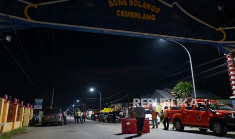 Petugas Dinas Perhubungan (Dishub), Polri dan Satpol PP berjaga di perbatasan Kabupaten Bone Bolango dan Kota Gorontalo di Kabila, Kabupaten Bone Bolango, Gorontalo, Selasa (5/5/2020) malam. Akses keluar masuk perbatasan wilayah itu ditutup dalam rangka penerapan Pembatasan Sosial Berskala Besar (PSBB) guna memutus mata rantai pandemi COVID-19