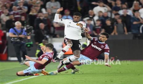 Aaron Cresswell (kiri) dan Lucas Paqueta dari West Ham United dan Lucas Paqueta berkombinasi untuk menghentikan pemain Manchester United, Marcus Rashford, selama pertandingan Liga Primer Inggris antara West Ham United dan Manchester United, di London, Inggris, Senin (8/5/2023) dini hari WIB. 