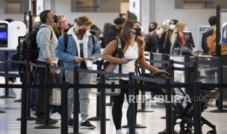  Pelancong menunggu untuk diperiksa oleh personel Administrasi Keamanan Transportasi (TSA) sebelum terbang di Bandara Nasional Ronald Reagan Washington di Arlington, Virginia, AS, 27 Desember 2021. Hingga saat ini kasus Omicron telah terdeteksi di 115 negara dengan total kasus lebih dari 184 ribu. 