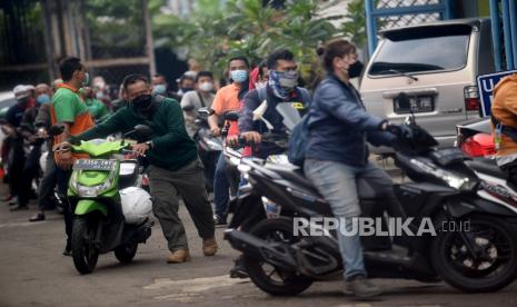 Warga mengantri untuk melakukan menguji emisi kendaraan bermotor di bengkel Dinas Lingkungan Hidup, Cililitan, Jakarta, Kamis (4/11). Dinas Lingkungan Hidup DKI Jakarta melayani uji emisi kendaraan bermotor gratis untuk sepeda motor maupun mobil  yang dibuka setiap Selasa dan Kamis untuk menekan tingkat pencemaran udara di Ibu Kota. Banyaknya warga yang ingin uji emisi mengakibatkan antrean panjang dan dibuka sejak pukul 08.00 WIB hingga pukul 14.00 WIB.Prayogi/Republika.