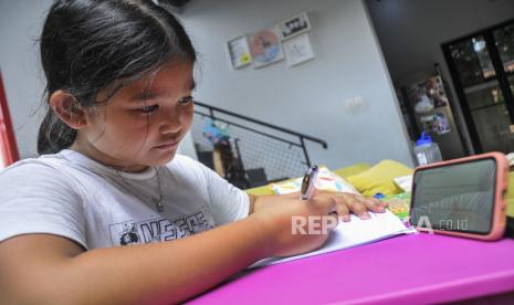 Siswi SD (Sekolah Dasar) belajar menggunakan sistem daring (online) di Jakarta Timur, Kamis (19/3/2020). 