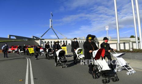  Aktivis Extinction Rebellion (XR) menggelar parade pemakaman kereta bayi kosong selama protes perubahan iklim di luar Gedung Parlemen di Canberra, Wilayah Ibu Kota Australia, Australia, 21 Oktober 2021. Menurut Extinction Rebellion Australia, kereta bayi putih kosong melambangkan 