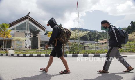 Dua Pekerja Migran Indonesia (PMI) bermasalah berjalan memasuki halaman Pos Lintas Batas Negara (PLBN) Entikong di Kabupaten Sanggau, Kalimantan Barat, Kamis (28/4/2022). Konsulat Jenderal Republik Indonesia (KJRI) Kuching membantu pemulangan seorang PMI (Pekerja Migran Indonesia), Meri Haspari, asal Purworejo, Jawa Tengah yang ditahan majikannya selama 17 tahun. 