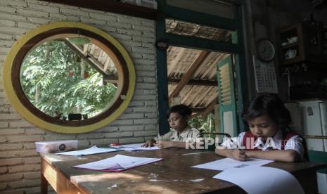 Dua orang siswa sekolah dasar mengerjakan soal ujian akhir semester di rumahnya di Bangunjiwo, Kasihan, Bantul, DI Yogyakarta, Selasa (8/6/2021). Gubernur Yogyakarta Sri Sultan HB X menyatakan sekolah tatap muka di wilayahnya dibuka setelah vaksinasi COVID-19 terhadap guru dan tenaga kependidikan selesai dilakukan  (Ilustrasi)