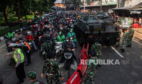 Petugas gabungan mengimbau pengendara untuk memutar balik saat melewati posko penyekatan pada jam berangkat kerja di Jalan Lenteng Agung, Jakarta Selatan, Senin (5/7). Penyekatan pada hari ketiga Pemberlakuan Pembatasan Kegiatan Masyarakat (PPKM) Darurat tersebut menyebabkan kemacetan sepanjang 2 kilometer. Republika/Thoudy Badai