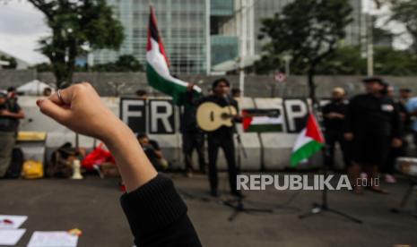 Massa aksi mengepalkan tangan saat aksi solidaritas untuk Palestina di depan Kedutaan Besar Amerika untuk Indonesia, Jakarta, Jumat (19/4/2024). Aksi yang digagas oleh para seniman yang mengatasnamakan Koalisi Musisi untuk Gaza dan KontraS tersebut untuk memberikan wadah bagi anak muda bersuara dan menuntut agar genosida di Palestina segera dihentikan.