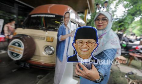 Simpatisan memperlihatkan kipas bergambar wajah calon presiden nomor urut 1 Anies Baswedan. Eks pegawai KPK menunggu bukti pernyataan Anies yang akan membenahi KPK.