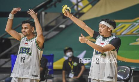 Aktor Raffi Ahmad (kiri) bersama penyanyi Djoni Permato (kanan) memberi semangat ke rekan satu timnya pada pertandingan basket IBL All Star 2022  