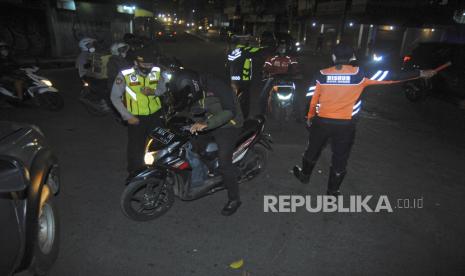 Personel Polresta Bogor Kota dan Dishub Kota Bogor mengatur arus lalu lintas saat penutupan ruas Jalan Simpang Empang di Kota Bogor, Jawa Barat, Jumat (2/7/2021). Satgas Penanganan COVID-19 Kota Bogor melakukan penutupan 10 ruas jalan di pusat Kota Bogor yang akan diterapkan setiap hari mulai pukul 21.00-24.00 WIB sebagai upaya pembatasan mobilitas masyarakat di tengah meningkatnya kasus positif COVID-19. 