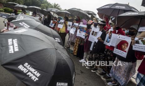 Sejumlah Ibu Pekerja Rumah Tangga (PRT) yang tergabung dalam Koalisi Sipil Untuk UU Perlindungan PRT melakukan aksi Rabuan PRT: Payung Duka Seribu Ibu-Ibu PRT Indonesia di Taman Aspirasi Monas, Jakarta, Rabu (21/12/2022). Dalam aksi tersebut, mereka mendesak Presiden dan Ketua DPR bersuara untuk mendukung pengesahan UU PPRT guna menghentikan kekerasan dan praktek perbudakan modern terhhadap ibu-ibu pekerja rumah tangga. 