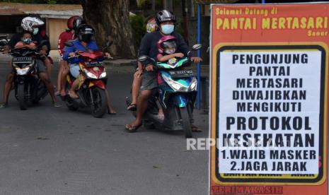 Pengunjung memasuki kawasan pantai pada hari pertama penerapan normal baru tahap I di Pantai Mertasari, Denpasar, Bali, Kamis (9/7/2020). Ilustrasi