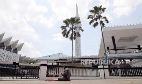 Malaysia Larang Area Sholat Masjid Jadikan Tempat Vaksinasi. Seorang muslim berdoa di luar Masjid Nasional, Kuala Lumpur, Malaysia.