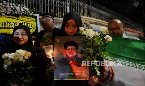 Warga menggelar aksi belasungkawa atas meninggalnya Presiden Republik Islam Iran di depan Kantor Kedutaan Besar Republika Islam Iran di Jakarta, Senin (20/5/2024). Aksi tersebut sebagai bentuk belasungkawa atas meninggalnya Presiden Iran Ebrahim Raisi, Menteri Luar Negeri  Hossein Amir Abdollahian beserta rombongannya atas insiden kecelakaan helikopter pada Ahad (19/5/2024) di pegunungan di Provinsi Azerbaijan Timur. Kedubes Iran juga mengibarkan bendera setengah tiang serta area kantornya dipenuhi oleh karangan bunga duka cita.