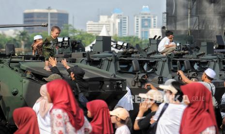 Pengunjung berfoto dengan kendaraan tempur TNI saat dipamerkan di area silang Monumen Nasional (Monas) Jakarta, Rabu (2/10/2024). Menjelang peringatan HUT ke-79 TNI yang akan berlangsung di Monas pada 5 Oktober mendatang, sejumlah kendaraan tempur, alutsista dan kendaraan Maung V3 dihadirkan di kawasan Monas dan menjadi spot foto para pengunjung.