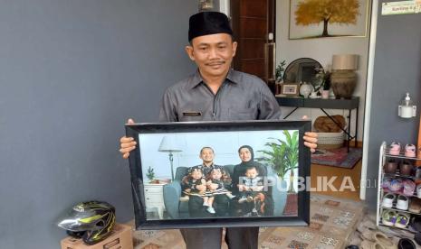 Kepala Desa Cihanjuang Gagan Wirahma memperlihatkan foto keluarga dari Farid Ahmad yang menjadi korban kecelakaan pesawat jatuh di wilayah BSD, Serpong, Tangerang, Senin (20/5/2024).