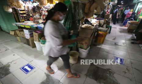 Tanda penunjuk arah jalan tertempel di lorong Pasar Genteng Baru, Surabaya, Jawa Timur, Ahad (14/6). Pemerintah Kota Surabaya menerapkan protokol kesehatan di pasar tersebut dengan memasang penyekat plastik di lapak pedagang, pemberlakuan sirkulasi pengunjung dengan sistem satu arah, wajib mengenakan masker, pengecekan suhu badan, pembatasan jumlah pengunjung pasar, serta transaksi menggunakan alat bantu nampan.