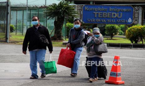 Sejumlah pelintas batas dari Malaysia berjalan melintasi kompleks Imigrasi Tebedu Sarawak Malaysia menuju Pos Lintas Batas Negara (PLBN) Entikong di Kabupaten Sanggau, Kalimantan Barat, Selasa (26/4/2022). Administrator PLBN Entikong Viktorius Dunand mengatakan bahwa sebagian besar pelintas batas dari Malaysia melalui pintu perbatasan tersebut adalah Pekerja Migran Indonesia dan pelaku perjalanan mandiri yang hendak berobat di Kuching, Sarawak, Malaysia.