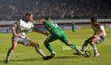 Sayap PSS Sleman Miftahul Hamdi ditahan dua bek Persib Bandung Nick Kuipers dan Rachmat Irianto.