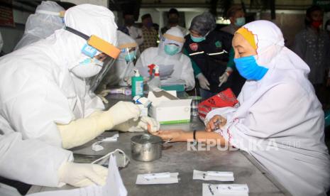 Petugas kesehatan mengambil sampel darah seorang jamaah untuk dilakukan tes diagnostik cepat atau rapid test COVID-19 