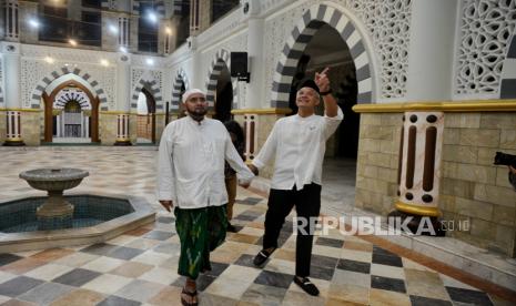 Calon presiden nomor urut 3, Ganjar Pranowo (kanan) berbincang dengan Ulama Habib Syech bin Abdul Qadir Assegaf (kiri) saat berkunjung ke kediamannya di Kota Surakarta, Jawa Tengah, Jumat (29/12/2023). Dalam agenda  kampanye di Surakarta, Ganjar Pranowo menyempatkan diri untuk bersilaturahim ke Habib Syech.