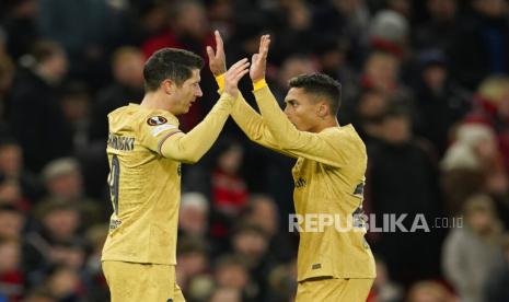 Pemain Barcelona  Robert Lewandowski (kiri) berselebrasi dengan rekan setimnya Raphinha setelah mencetak gol pembuka timnya pada pertandingan sepak bola leg kedua playoff Liga Europa antara Manchester United dan Barcelona di stadion Old Trafford di Manchester, Inggris, Jumat (24/2/2023) dini hari WIB 