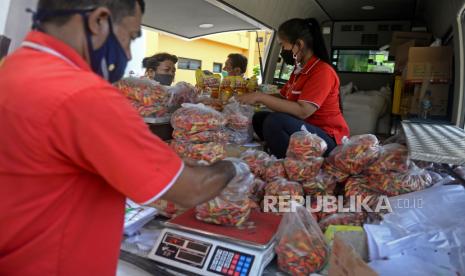 Petugas mealayani warga yang membeli cabai saat Gelar Pangan Murah (GPM) yang dilaksanakan oleh kementerian pertanian di Rusunawa Jatirawasari, Jakarta, Senin (12/4). Kegiatan Gelar Pangan Murah (GPM) ini ditujukan untuk memperkuat dan mempermudah akses masyarakat terhadap bahan pangan yang berkualitas dan terjangkau menjelang Ramadhan.  Prayogi/Republika