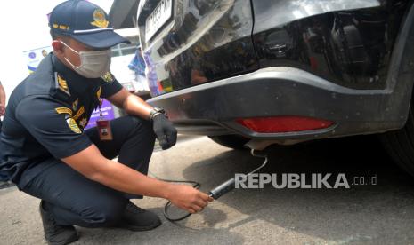 Petugas Dinas Perhubungan Kota Yogyakarta memasang alat pengukur emisi saat uji emisi gratis kendaraan roda empat di Yogyakarta, Kamis (14/9/2023). Uji emisi gratis ini untuk mengetahui kadar karbon kendaraan masyarakat. Selain itu juga untuk pemantauan pencemaran emisi sumber bergerak. Untuk kendaraan bensin yang diuji yakni kadar hidrokarbon dan karbon monoksida. Bagi kendaraan yang lolos akan diberikan sticker lulus uji emisi.