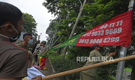 Personel Satpol PP Kota Serang menertibkan spanduk dan baliho reklame ilegal di Jalan Sudirman, Serang, Banten, Senin (1/2/2021). Petugas menggelar razia reklame ilegal untuk menegakkan peraturan daerah serta menjaga kebersihan kota di masa pembatasan kegiatan masyarakat.