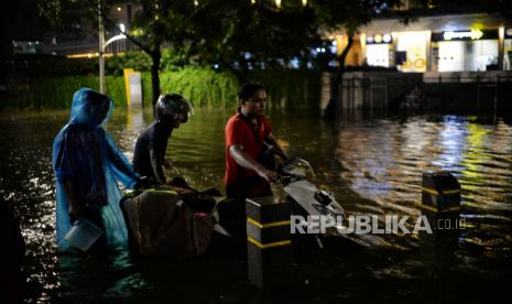 Pengendara mendorong motornya saat menerobos banjir di Jalan Kemang Raya, Jakarta Selatan, Selasa (5/10/2022). Banjir setinggi kurang lebih satu meter tersebut terjadi akibat dari luapan Kali Krukut setelah hujan deras pada sore hari, hingga malam hari pukul 20.36 WIB banjir tersebut belum surut. Republika/Thoudy Badai