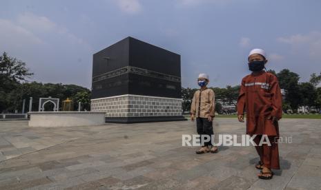 DPR Ajak Menag Sosialisasi Pembatalan Haji. Anak-anak melintasi area tempat latihan manasik Haji di Asrama Haji Pondok Gede, Jakarta, Jumat (26/6). Asrama Haji Pondok Gede tidak menyelenggarakan kegiatan karantina dan pembekalan sebelum berangkat ibadah ke tanah suci tahun ini karena pemerintah Indonesia membatalkan seluruh pemberangkatan haji akibat pandemi virus Corona. Republika/Putra M. Akbar