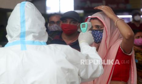  Seorang petugas kesehatan memeriksa suhu penumpang di stasiun kereta Bandra di Mumbai, India, Rabu, 17 Februari 2021. Pejabat kesehatan telah mendeteksi lonjakan kasus Covid-19 di beberapa kantong negara bagian Maharashtra, termasuk di Mumbai, negara tersebut. Modal finansial.