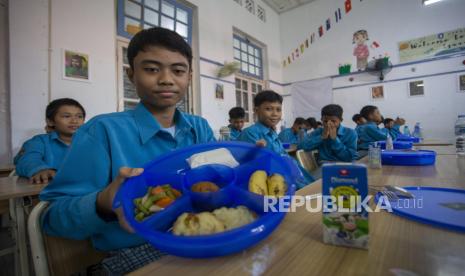 Siswa menunjukkan menu makanan bergizi gratis saat kegiatan mitigasi operasional dan uji coba makan bergizi gratis (MBG) di SMPN 1 Cirebon, Kota Cirebon, Jawa Barat, Rabu (25/9/2024).