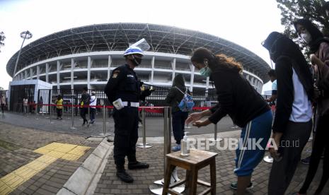 Sejumlah warga menggunakan cairan pembersih tangan saat antre untuk berolahraga di bagian luar Stadion Utama, Kompleks Gelora Bung Karno (GBK), Jakarta, Minggu (22/11/2020). Seluruh venue GBK ditutup sementara hingga 25 Januari 2021.