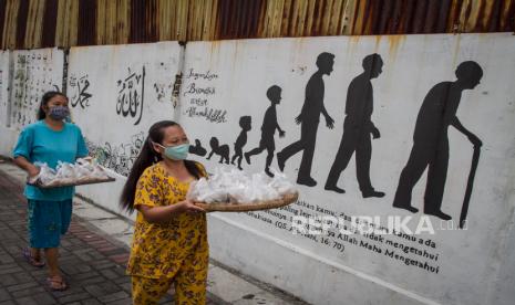 Warga Satgas Jaga Tangga RW VI mengantarkan menu makan untuk warga yang menjalani karantina di Bumi Laweyan, Solo, Jawa Tengah, Selasa (27/10/2020). Sebagai bentuk solidaritas Tim Satgas Jaga Tangga RW VI Bumi, Laweyan setiap hari memasak untuk 106 warga yang sedang menjalani karantina wilayah selama dua pekan akibat sejumlah warga melakukan kontak dengan warga lainnya yang terkonfirmasi positif COVID-19. 