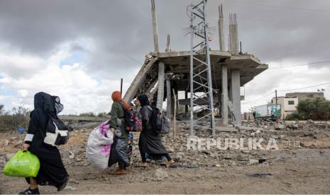 Wanita Palestina yang telantar membawa barang-barang mereka setelah perintah evakuasi dikeluarkan tentara Israel, di Rafah, 6 Mei 2024.