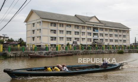 Perahu bermesin (klotok) melintas di kawasan Rusunawa Teluk Kalayan, Banjarmasin, Kalimantan Selatan, Rabu (22/6/2022). Kementerian PUPR tengah menyusun instrumen Sertifikat Kepemilikan Bangunan Gedung (SKBG) Satuan Rumah Susun (Sarusun)