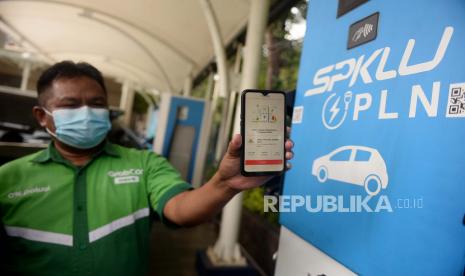 Seorang pengemudi menunjukan aplikasi PLN Charge.IN ketika melakukan mengisi daya mobil listrik di Stasiun Pengisian Kendaraan Listrik Umum (SPKLU) PLN di Kantor PLN Disjaya, Gambir, Jakarta Pusat, Jumat (29/1).