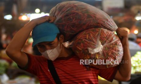 Warga memanggul cabai di Pasar Induk Kramat Jati, Jakarta, Senin (18/4/2022). Menurut sejumlah pedagang, pada hari ke-16 puasa Ramadhan 1443 H harga sejumlah komoditas pangan di Pasar Induk Kramat Jati relatif stabil seperti bawang merah berkisar Rp22ribu-35ribu/kg, bawang putih kating Rp28ribu/kg,  cabai rawit Rp20ribu-25ribu/kg, dan cabai merah keriting Rp23ribu/kg. 