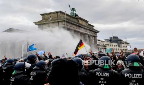 Polisi anti-huru-hara menggunakan meriam air untuk membubarkan demonstrasi menentang pembatasan virus corona Jerman, di dekat Gerbang Brandenburg di Berlin, Jerman, 18 November 2020.