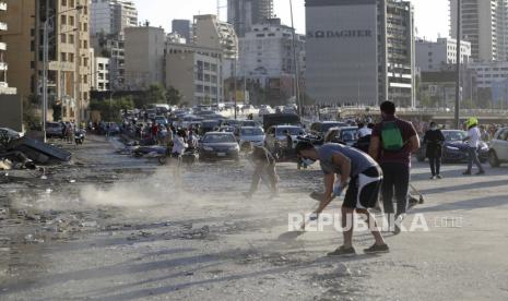  Orang-orang membersihkan setelah ledakan besar di Beirut, Lebanon, Rabu, 5 Agustus 2020. Ledakan besar-besaran mengguncang pusat kota Beirut pada hari Selasa, meratakan sebagian besar pelabuhan, merusak bangunan dan meledakkan jendela dan pintu saat awan jamur raksasa naik di atas modal. Saksi mata melihat banyak orang terluka oleh kaca terbang dan puing-puing.