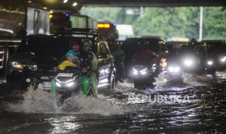 Sejumlah pengendara motor melewati genangan air (ilustrasi). BMKG memprediksi hujan ringan hingga sedang mendominasi cuaca sepekan menjelang Lebaran.