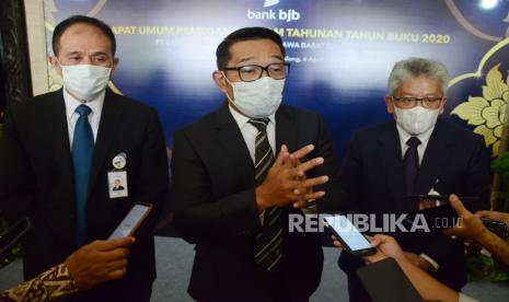 Gubernur Jawa Barat Ridwan Kamil (tengah) Direktur Utama Bank BJB Yuddy Renaldy (kanan) dan Komisaris Utama Independen Bank BJB Farid Rahman (kiri) menyampaikan keterangan pers usai Rapat Umum Pemegang Saham Tahunan (RUPST) Tahun Buku 2020 Bank BJB di The Trans Luxury Hotel, Kota Bandung, Selasa (6/4). Di tengah gejolak pandemi Covid-19 dan resesi ekonomi global, Bank BJB mampu bertumbuh dengan baik dan berhasil mencatatkan perolehan laba dan kinerja yang positif, ditunjukan lewat perolehan laba bersih yang naik sebesar Rp 126 miliar atau tumbuh sebesar 8,0% year on year (y-o-y), atas pencapaian ini pertumbuhan Bank BJB mampu tumbuh di atas rata-rata industri perbankan nasional maupun pertumbuhan di kelompok Bank Pembangunan Daerah sebesar 5,64%. Selain penyampaian kinerja, hasil RUPST terdapat perubahan pada susunan Dewan Komisaris dan Direksi Bank BJB.